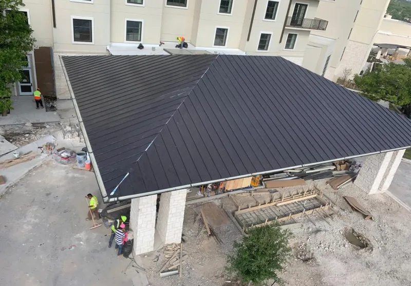 Metal roofing installation team working on a commercial building in Lowell